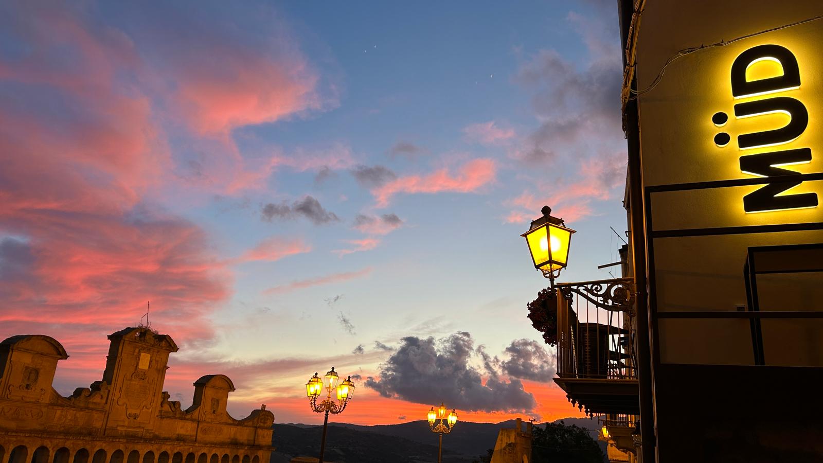 Il tramonto sulla Granfonte con l'insegna luminosa di MÜD